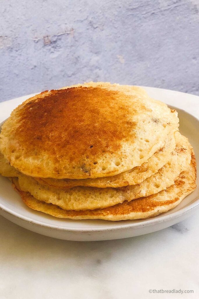 A stack of whole wheat healthy pancakes on a white plate.