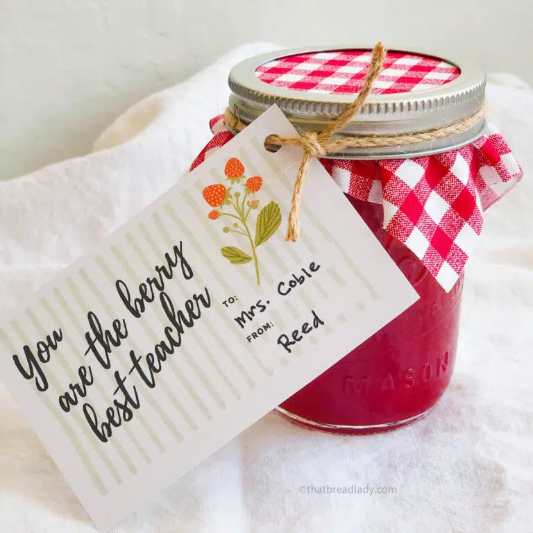 A jar of strawberry jam with a teacher appreciation gift tag tied to the lid.