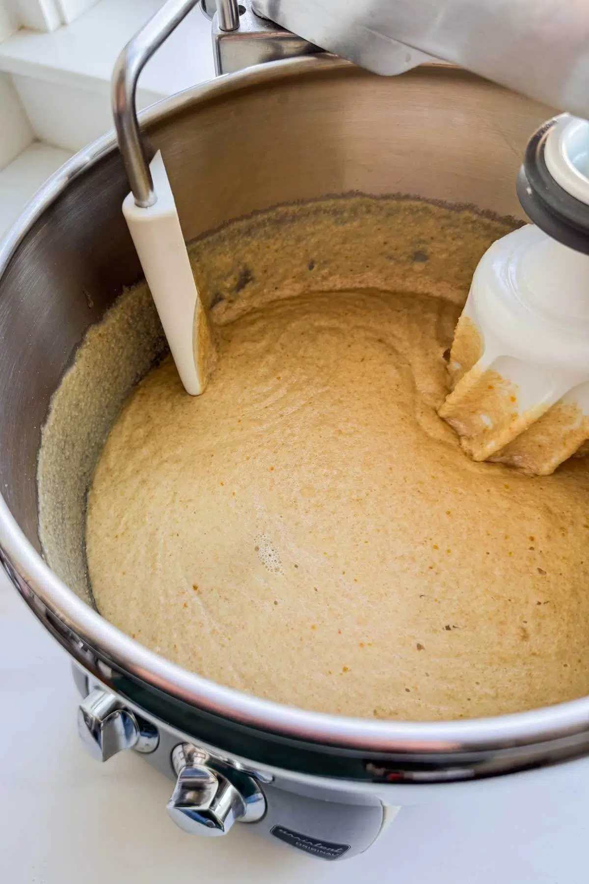The sponge mixture for honey whole wheat bread in a mixer.