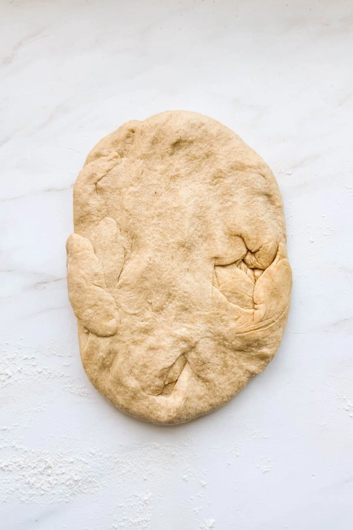 A flatten pieced of honey whole wheat bread dough.