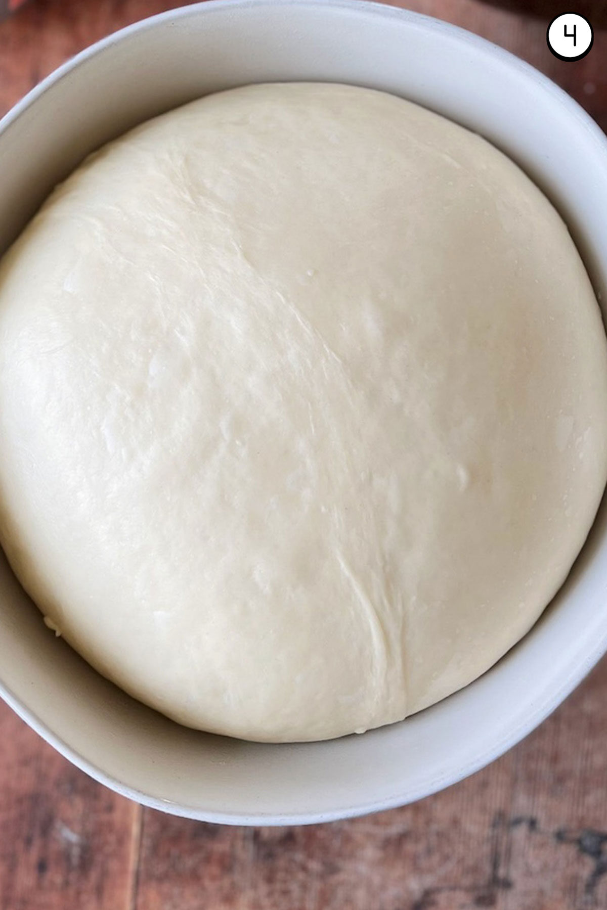 A bowl with risen crescent roll dough inside.