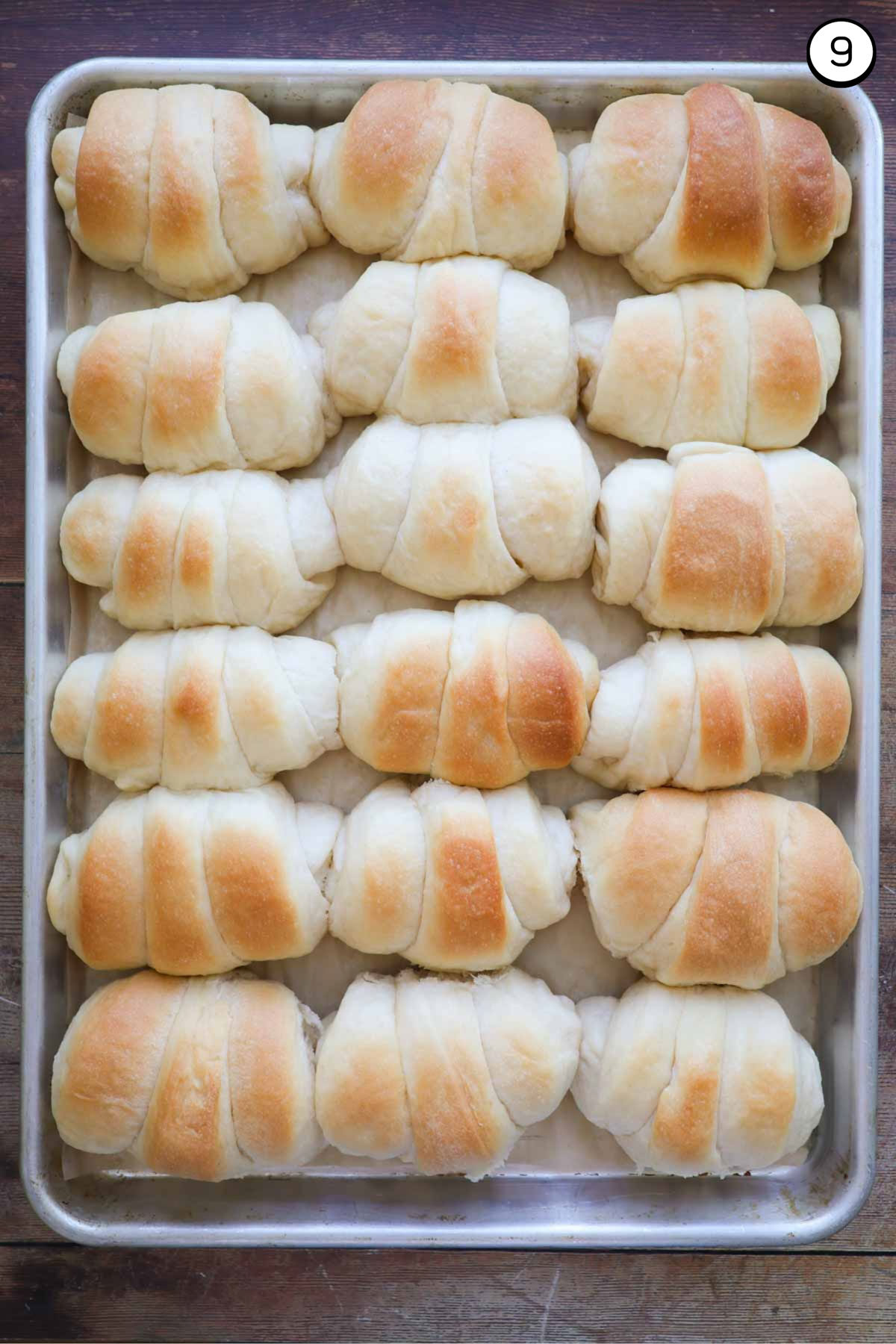 A baking sheet full of golden, baked crescent rolls.