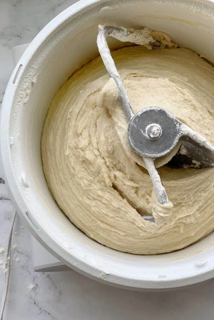 Bread dough being mixed in a mixer. 