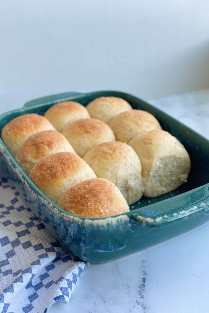 Whole grain dinner rolls in a baking dish.