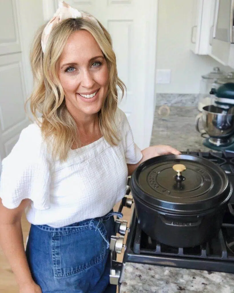 Heather Thomas, creator of That Bread Lady, standing at the kitchen counter, holding a cast iron Dutch oven.