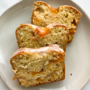 Three slices of peach bread resting on a white plate.