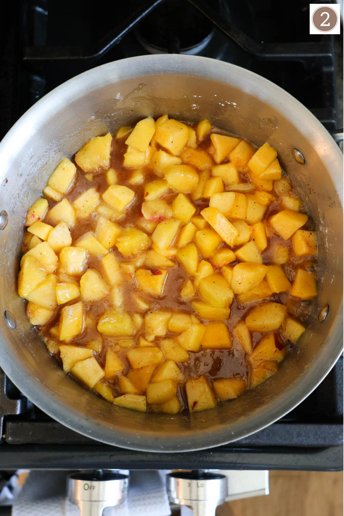 A saucepan filled with peaches simmering on the stove.