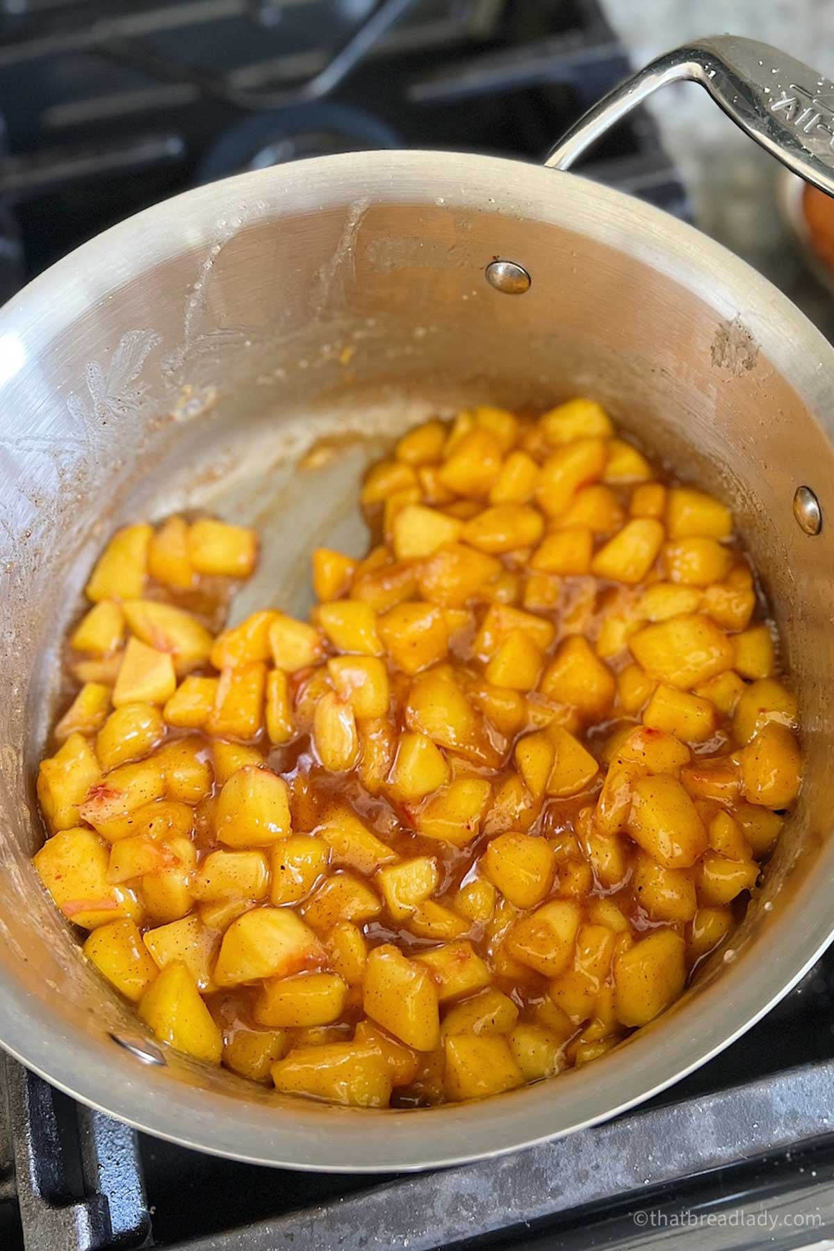 Cooked peaches in a saucepan.