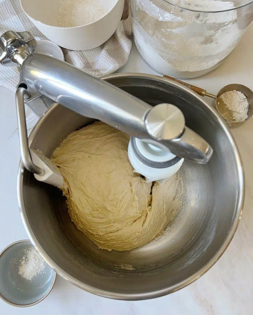 An Ankarsrum mixer with blueberry lemon roll dough in the stainless steel bowl.