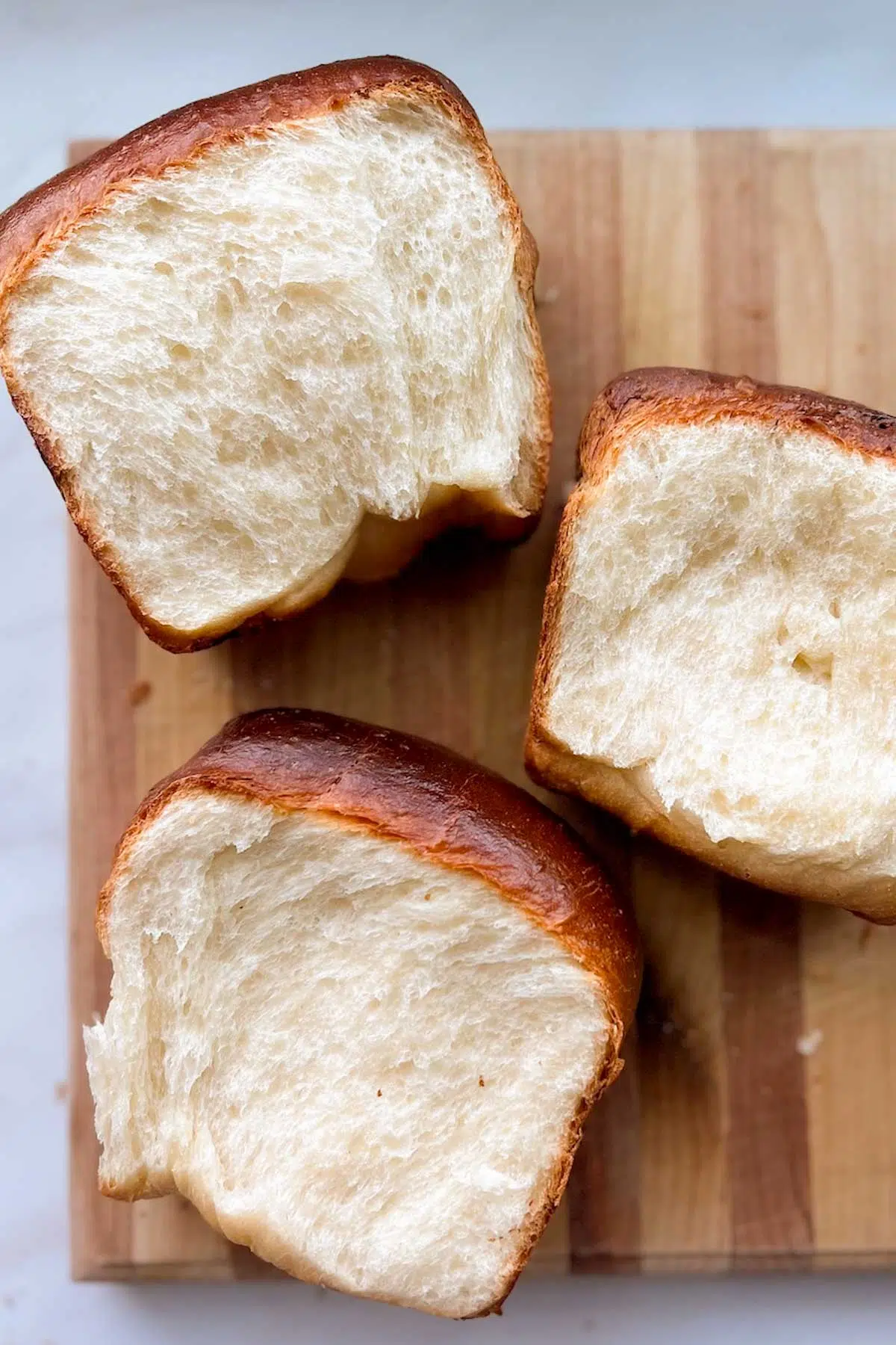 Three cross sections of white bread, resting on a cutting board.