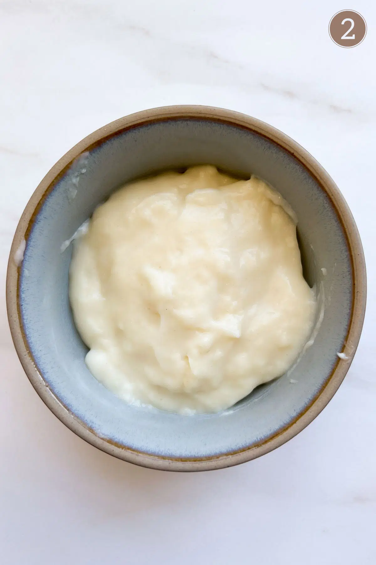 A blue bowl filled with a thick white mixture of tangzhong.