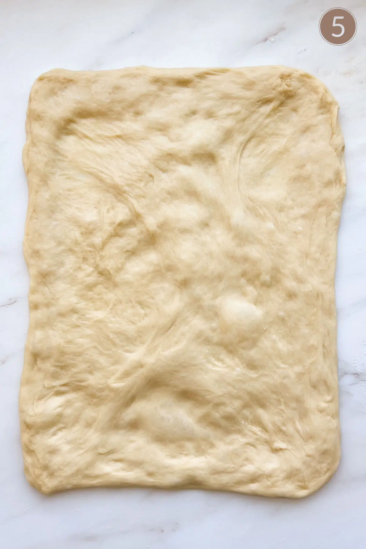 Bread dough flattened to a rectangle.