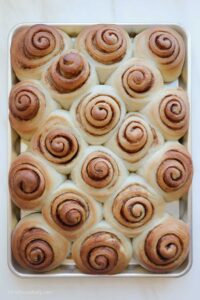 Baked Biscoff cinnamon rolls on a baking sheet.