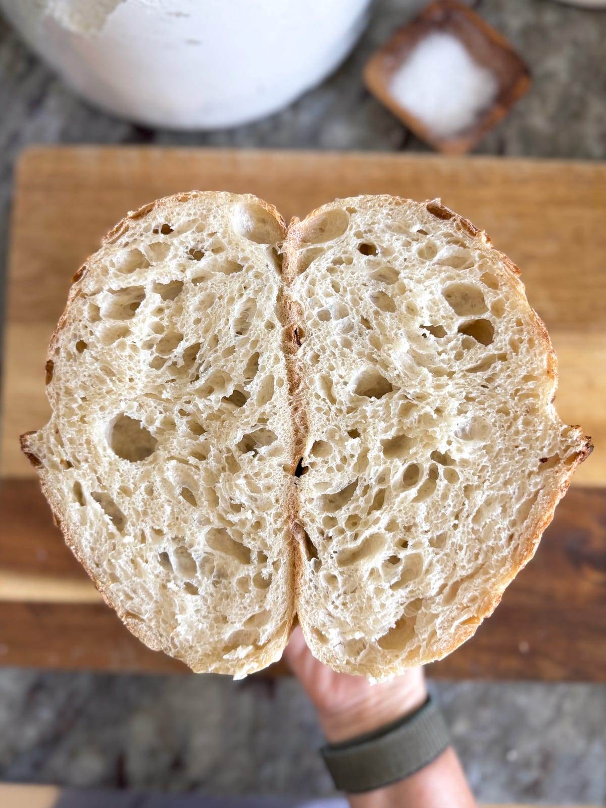 A loaf of sourdough bread cut in half and showing the inside crumb.