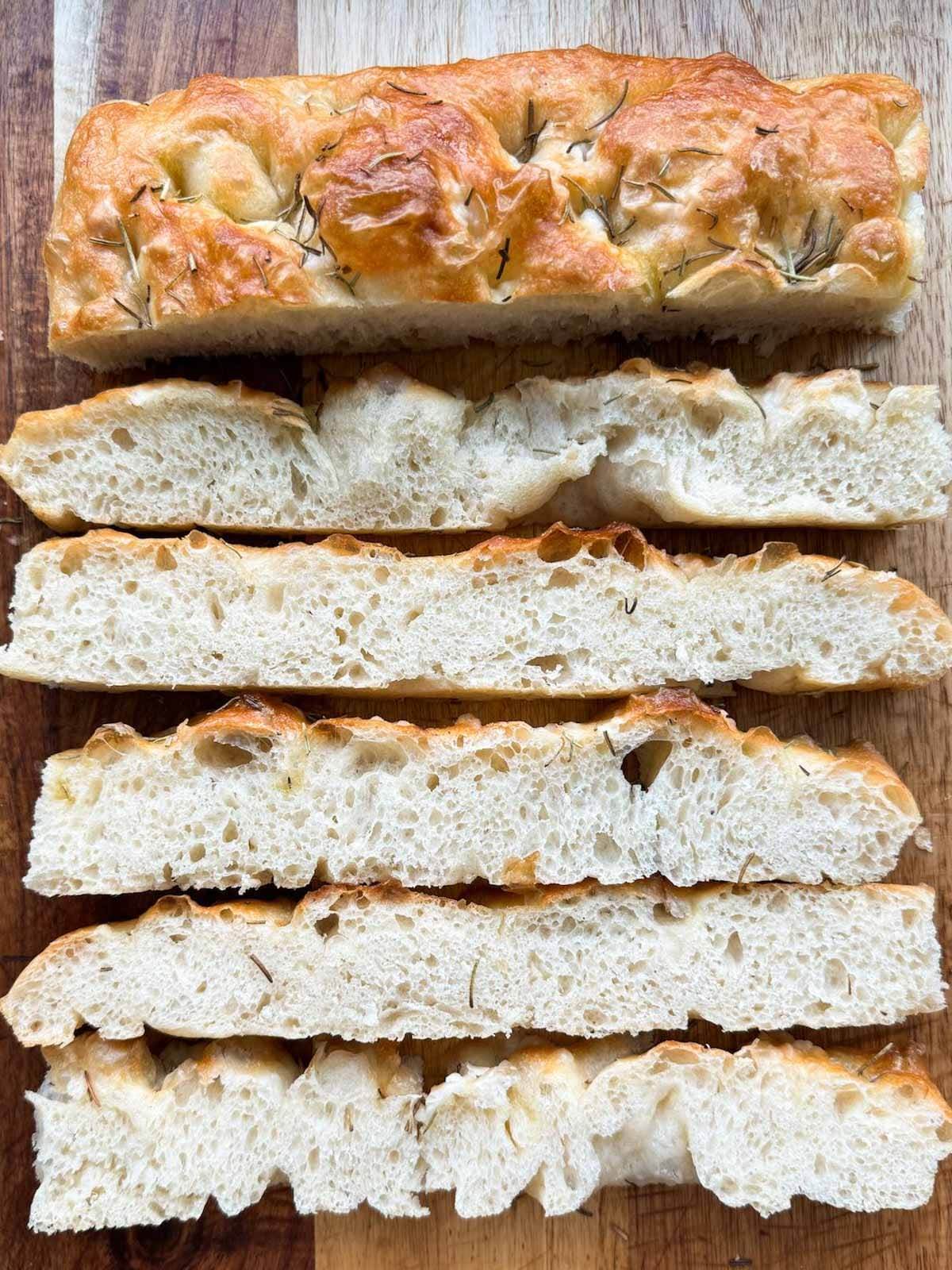 Focaccia sliced on a wood cutting board.