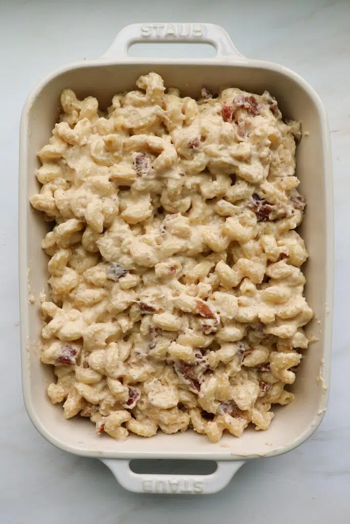 A white, 9 by 13-inch casserole dish filled with bacon mac and cheese.