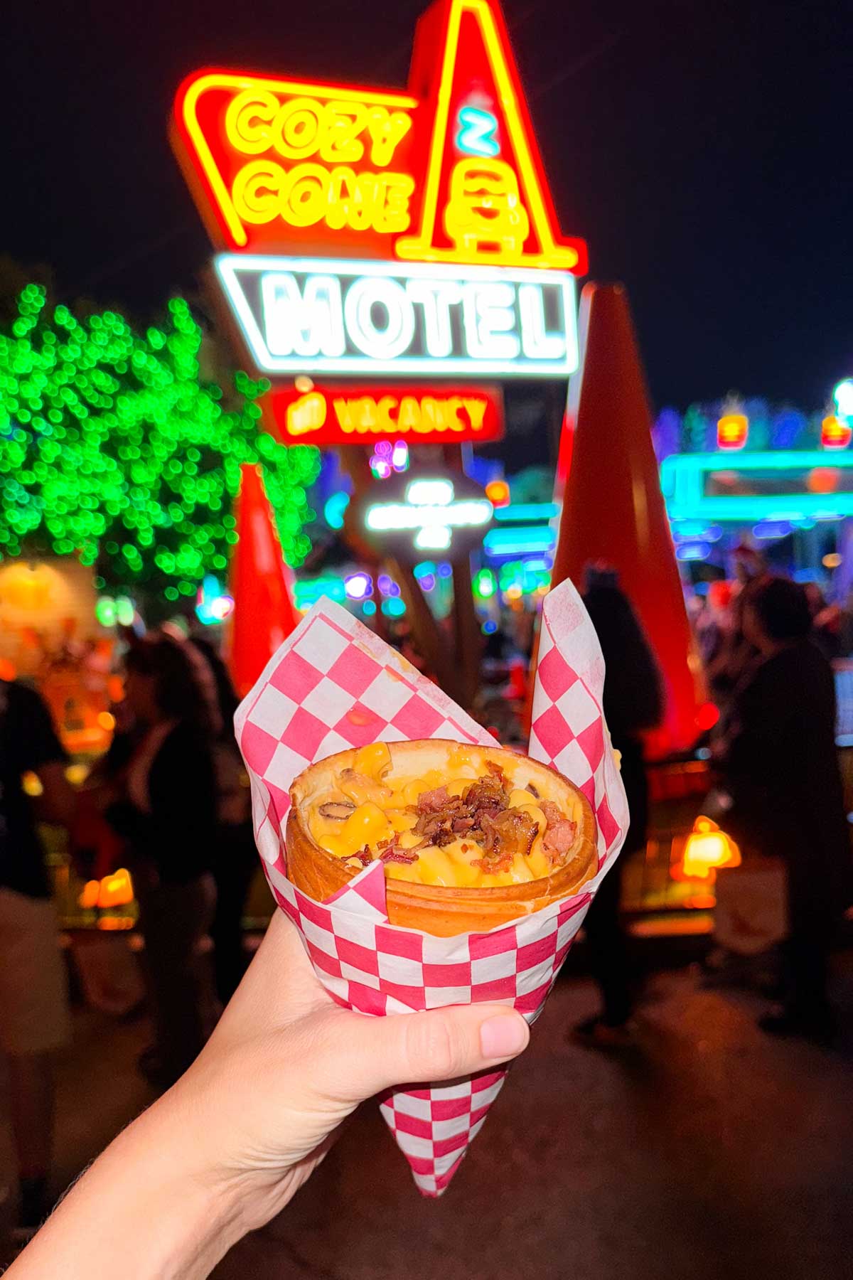 A bacon mac and cheese bread cone in front of the Cozy Cone Motel at Disney California Adventures.