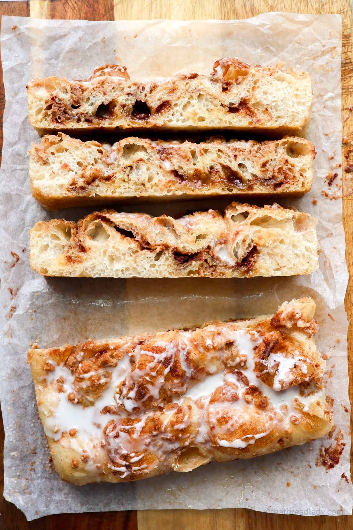 Cinnamon Roll focaccia, sliced on a wood cutting board.