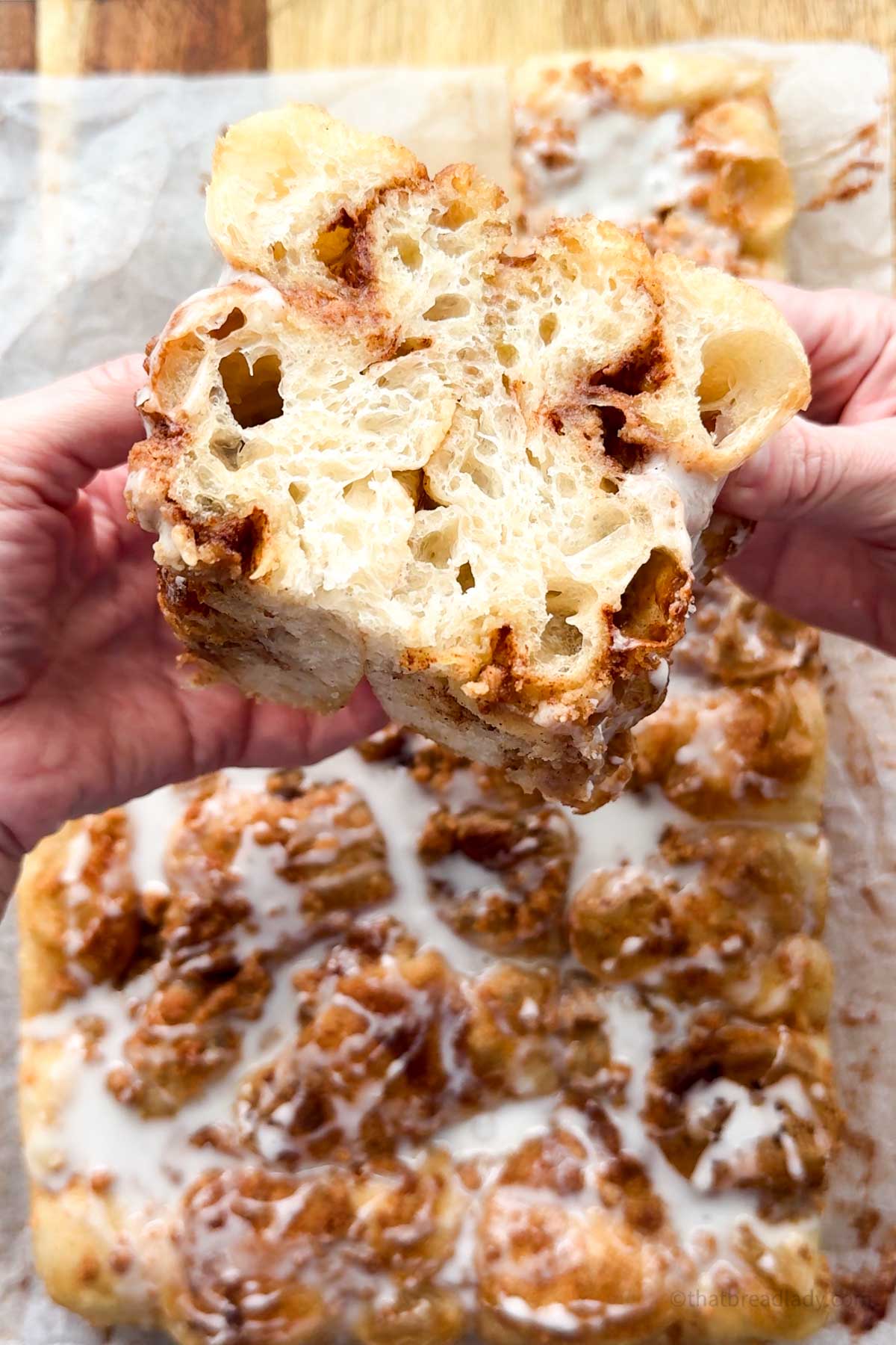 A slice of cinnamon roll focaccia showing the cinnamon swirls inside.