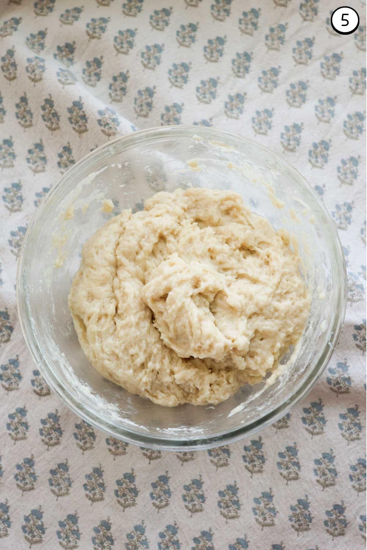 A glass bowl, with a thick biscuit mixture in it.