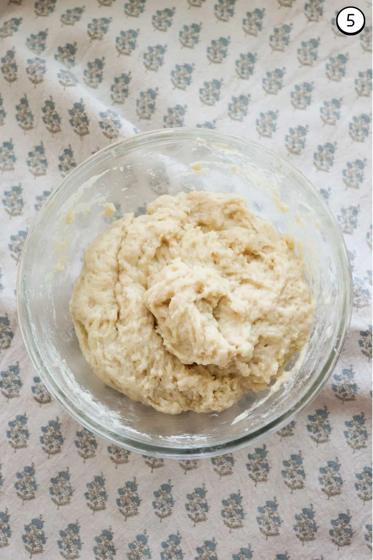 A glass bowl, with a thick biscuit mixture in it.