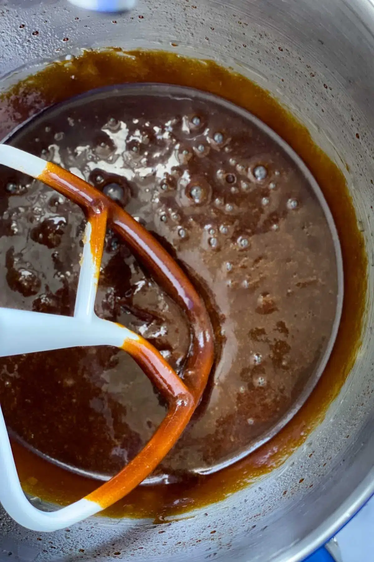 The molasses, vegetable oil, brown sugar, and egg, mixed together inside a stand mixer bowl with the paddle attachment.