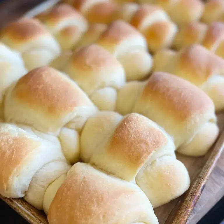 Baked homemade crescent rolls on a baking sheet.