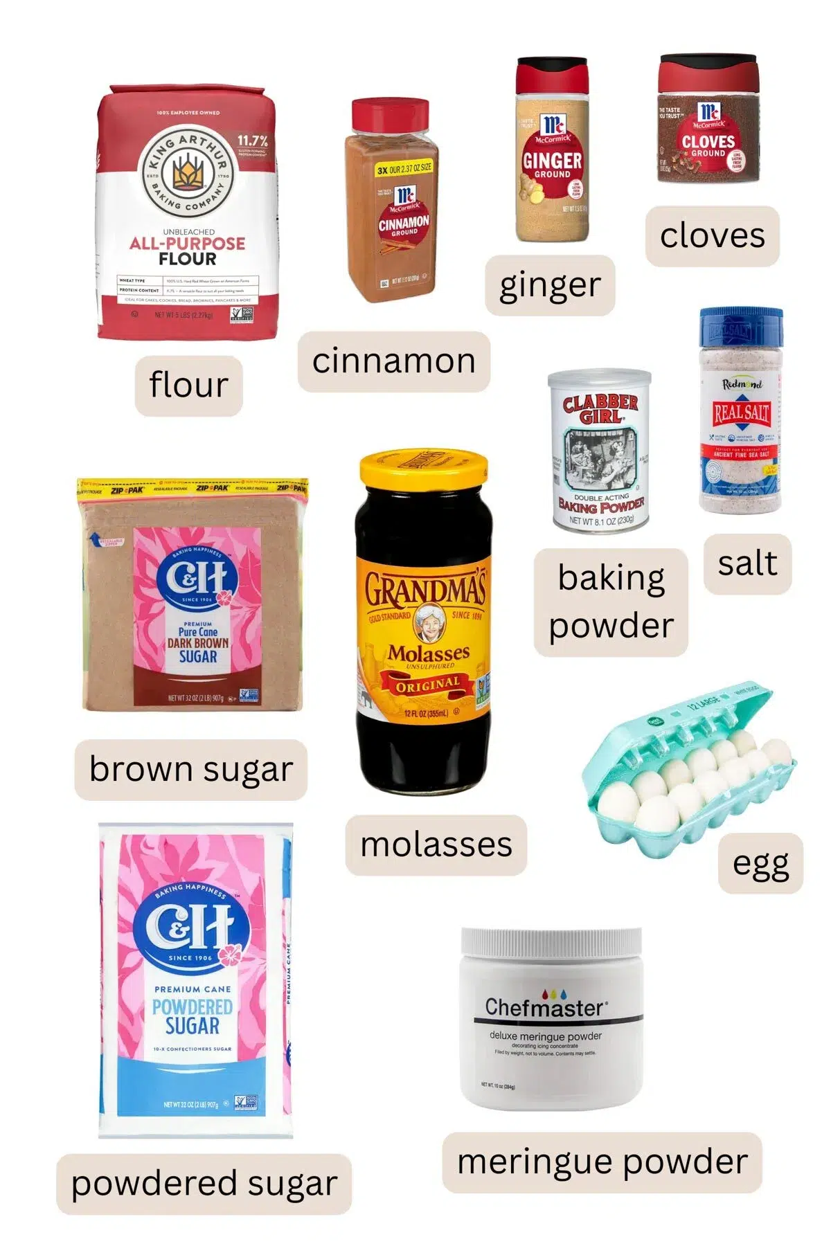 All the ingredients for a homemade gingerbread house including flour, cinnamon, ginger, cloves, brown sugar, molasses, baking powder, salt, eggs, powdered sugar, and meringue powder.