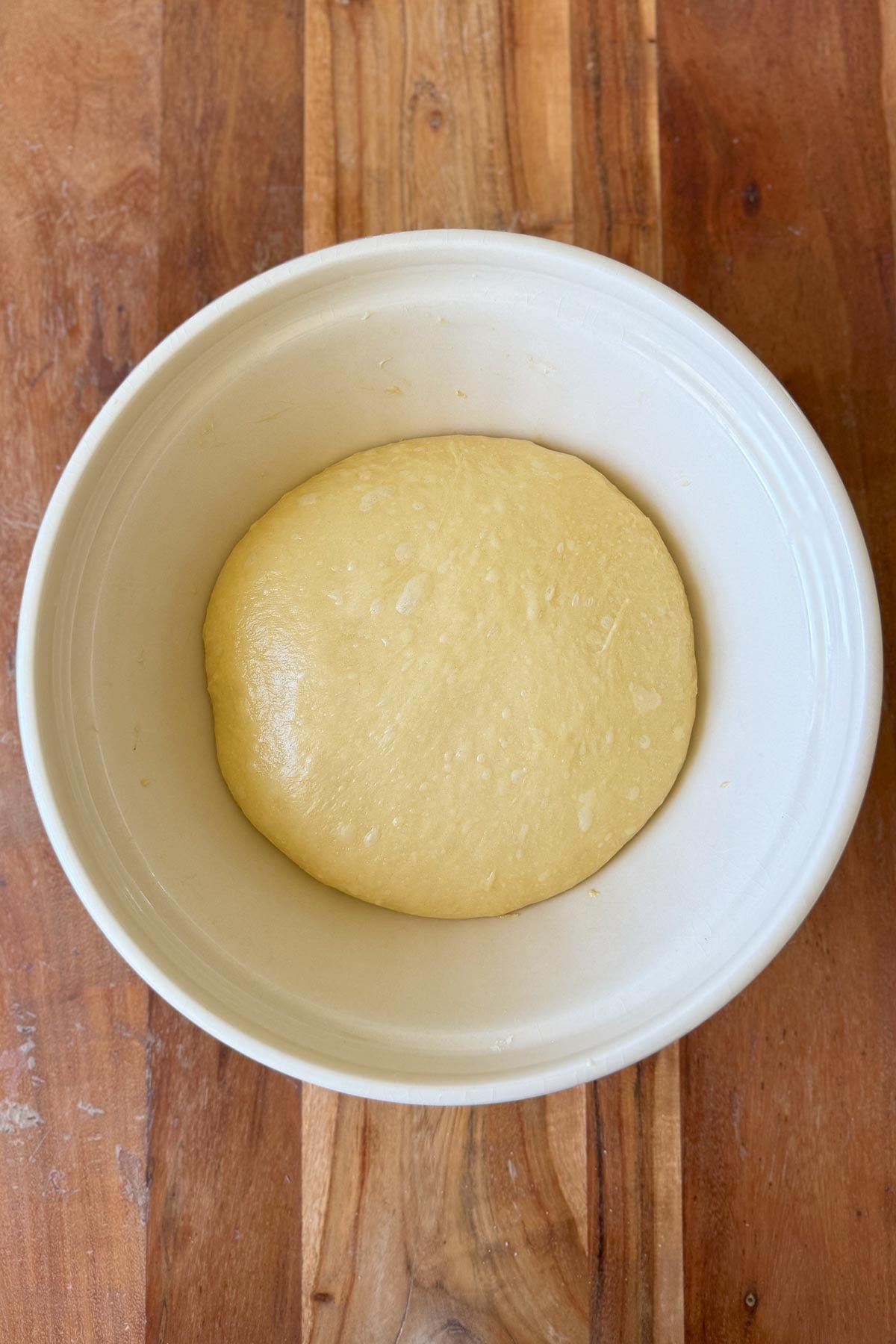 A bowl with brioche dough resting in it.