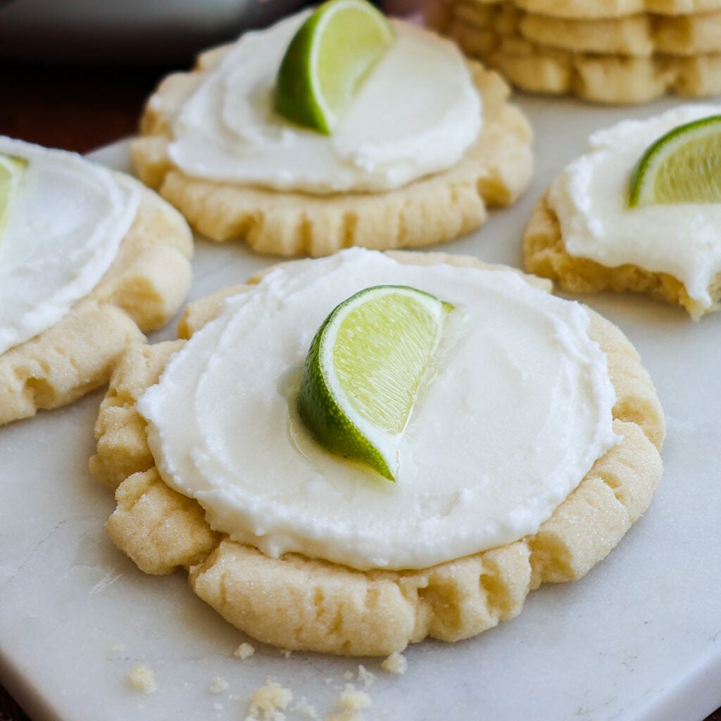 A coconut lime cookie, frosted with a lime wedge on top.