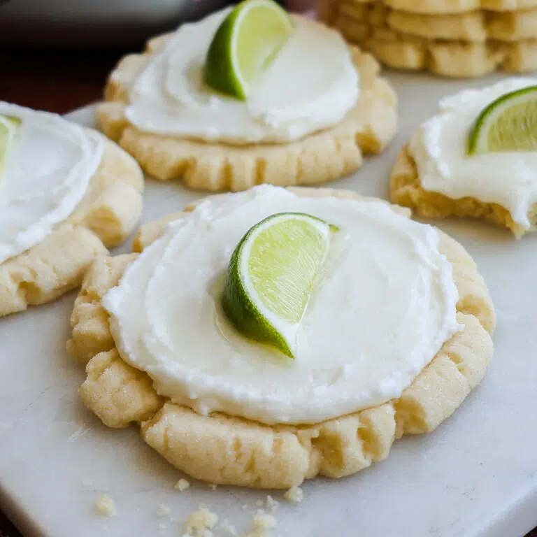 A coconut lime cookie, frosted with a lime wedge on top.