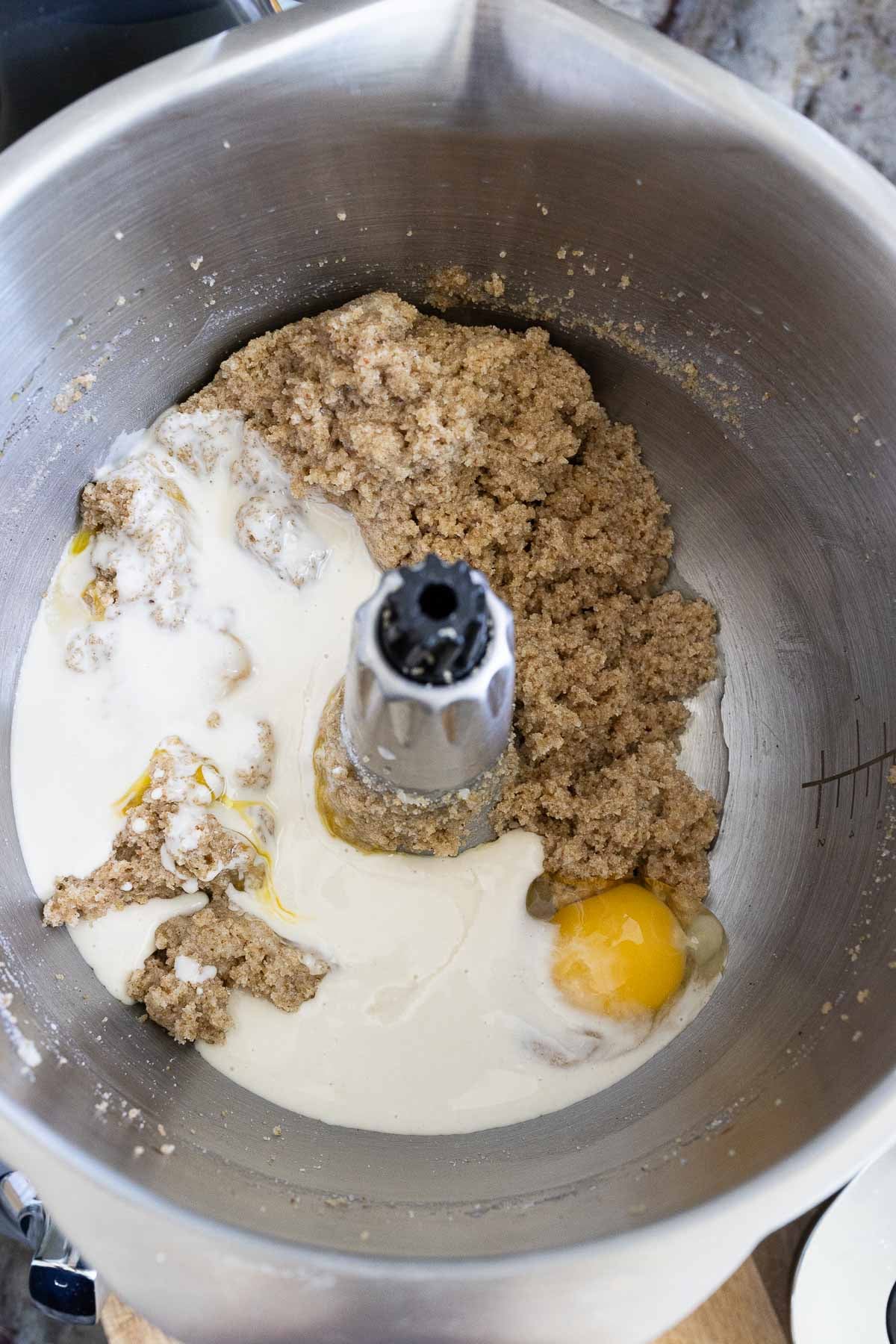Sourdough discard, eggs, and vanilla, added to the mixer bowl containing sugars and butter that have already been mixed.