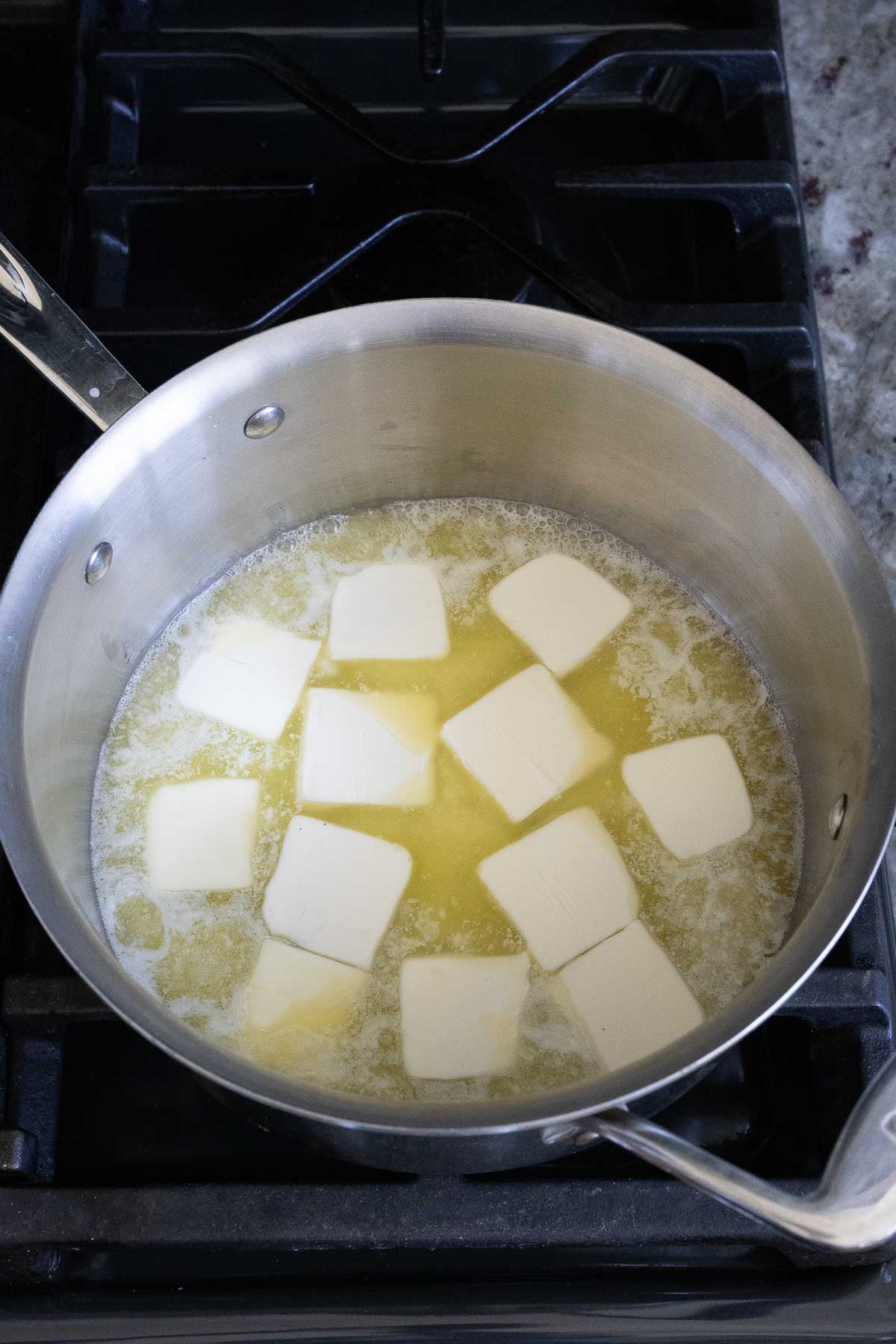 Sliced butter melting in a saucepan.
