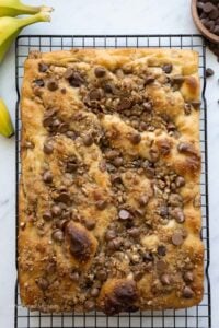 Baked chocolate chip banana bread focaccia on a wire cooling rack.