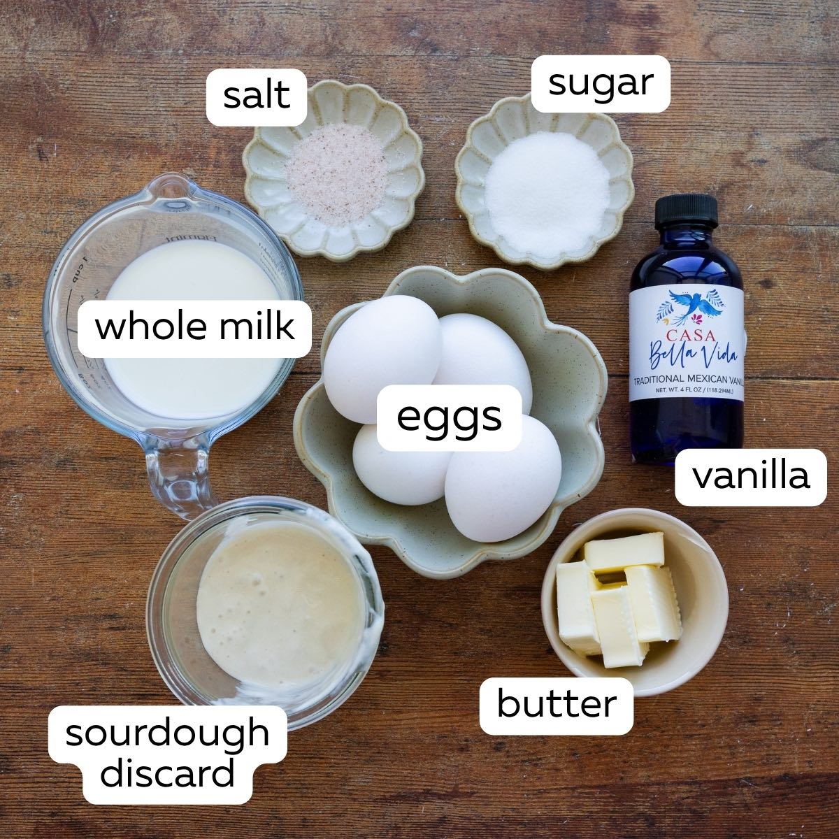 All the ingredients for sourdough Dutch baby pancakes including eggs, sourdough discard, butter, vanilla, sugar, salt, and whole milk.