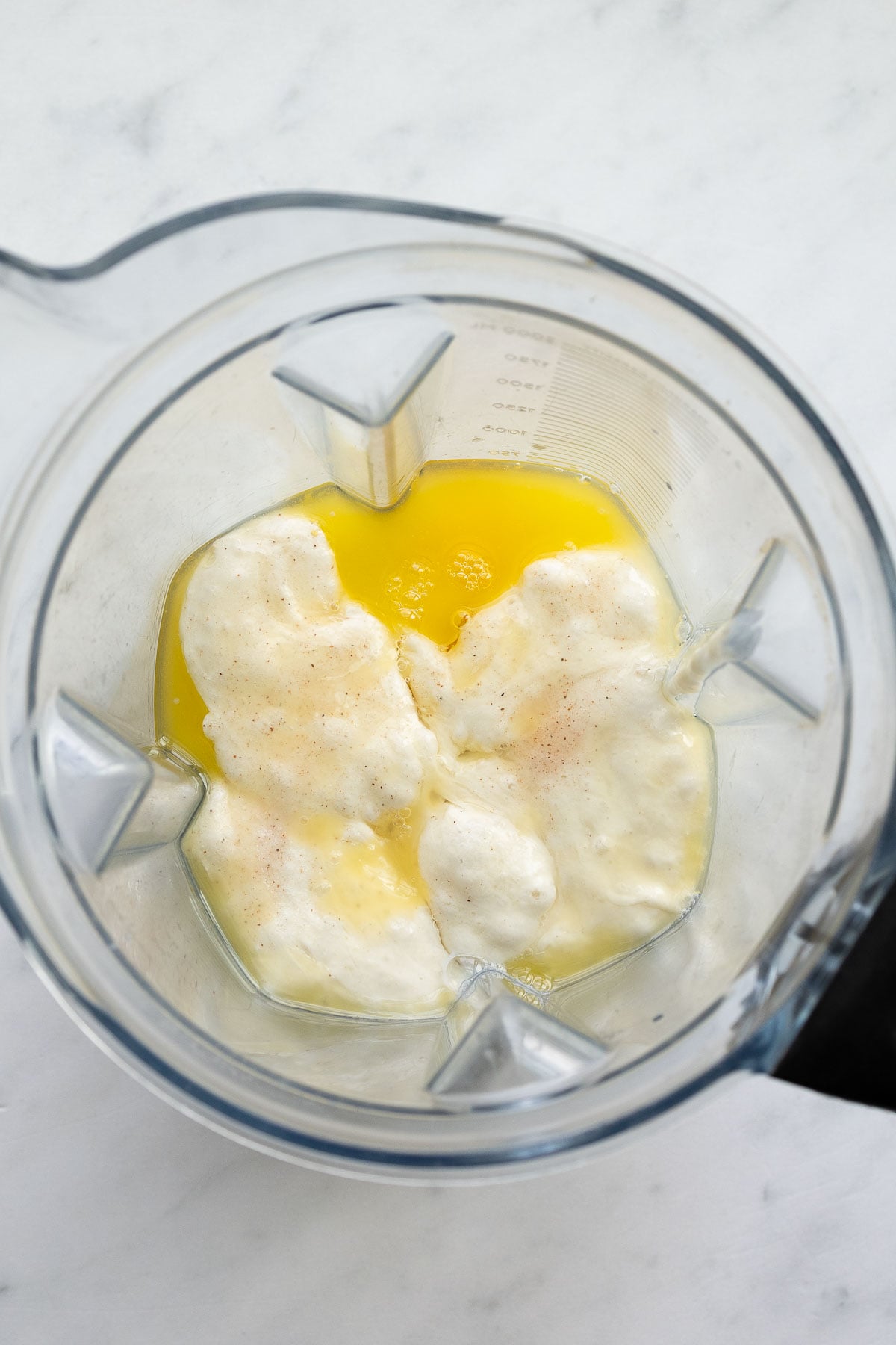 A blender with all the unmixed ingredients for sourdough Dutch baby pancakes in it.