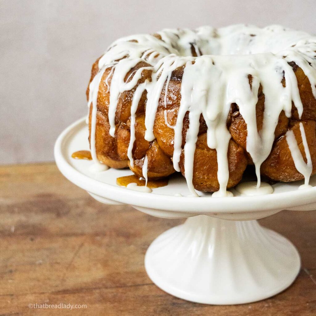 Monkey bread with icing, on a cake plate.