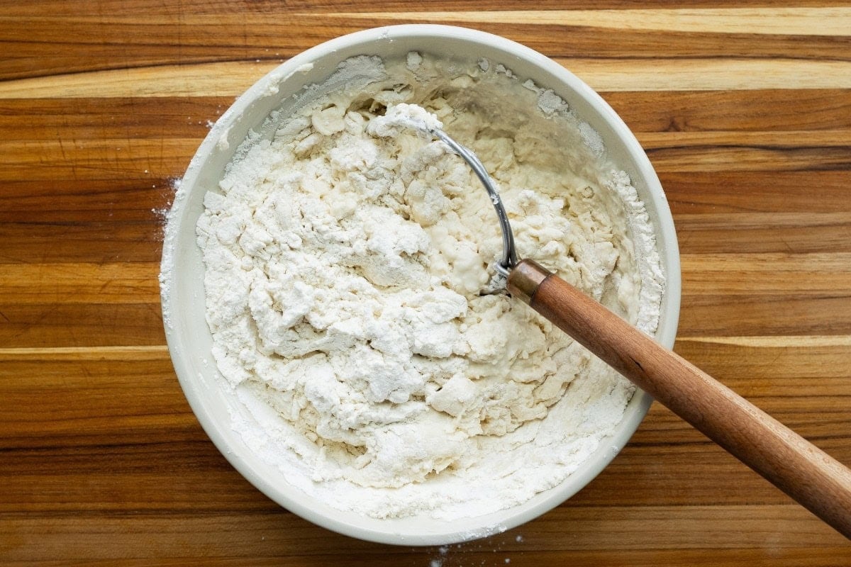 Flour, water, salt, and yeast, in a mixing bowl with a Danish whisk.