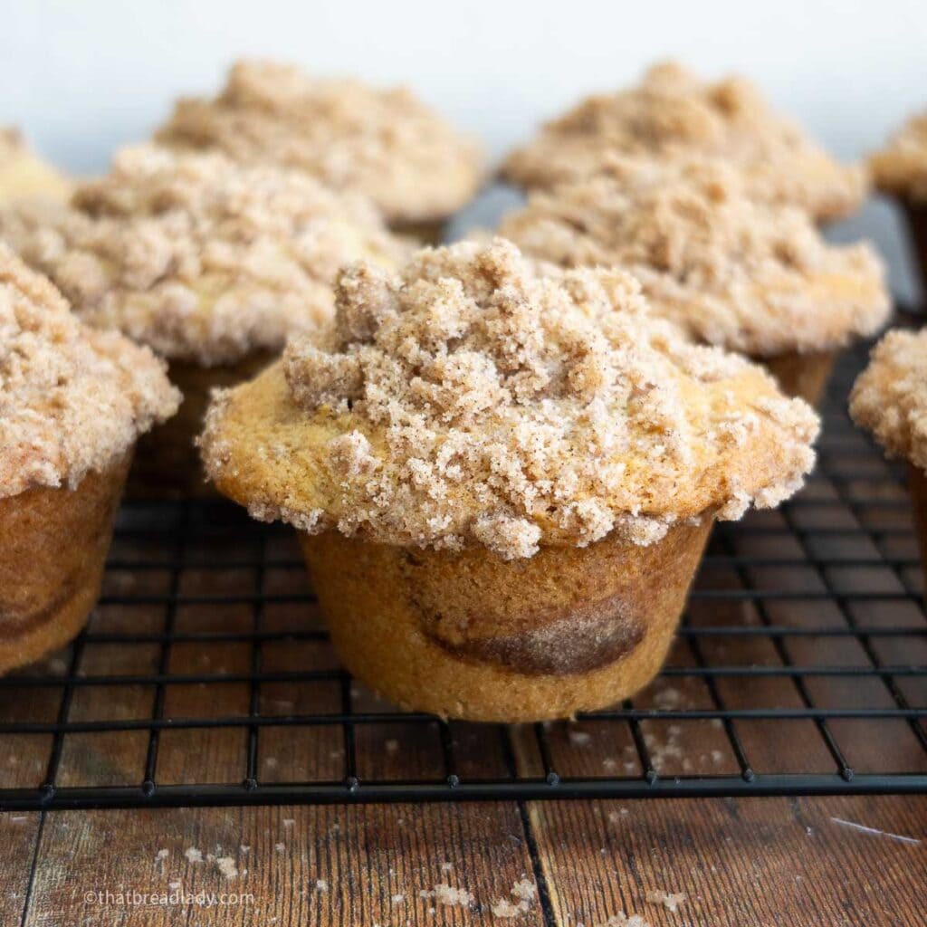 Sourdough coffee cake muffins resting on a wire cooling rack.